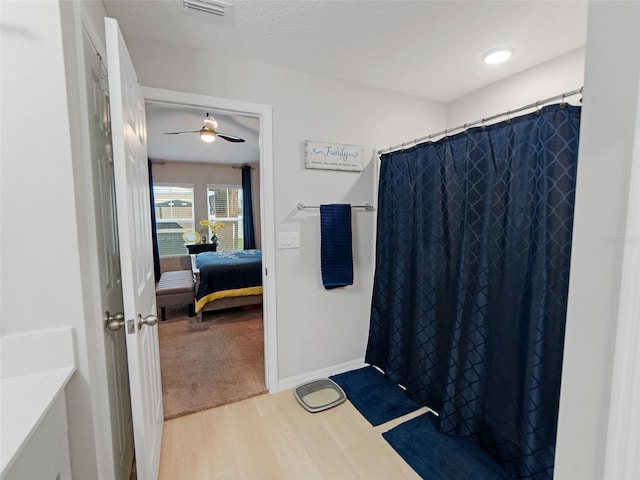 ensuite bathroom with wood finished floors, visible vents, baseboards, ensuite bath, and curtained shower