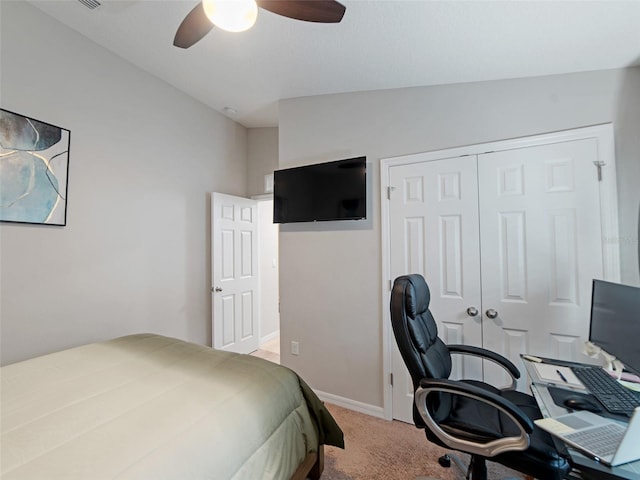 bedroom featuring baseboards, a ceiling fan, a closet, and light carpet