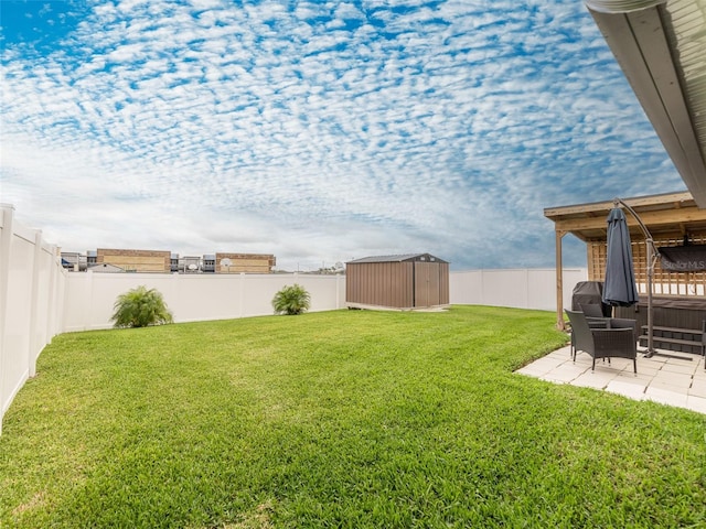 view of yard with a storage unit, an outbuilding, a fenced backyard, and a patio area