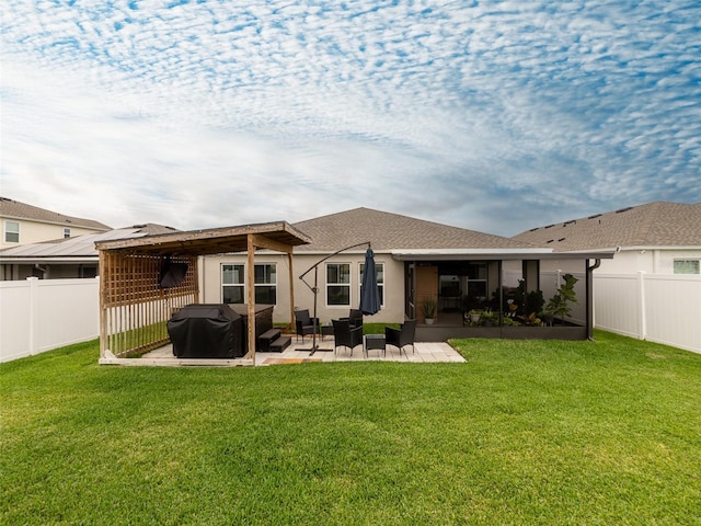 rear view of property with a patio, a fenced backyard, a lawn, and a shingled roof