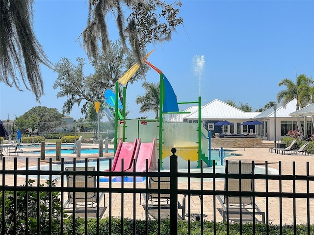 view of play area with a community pool and fence