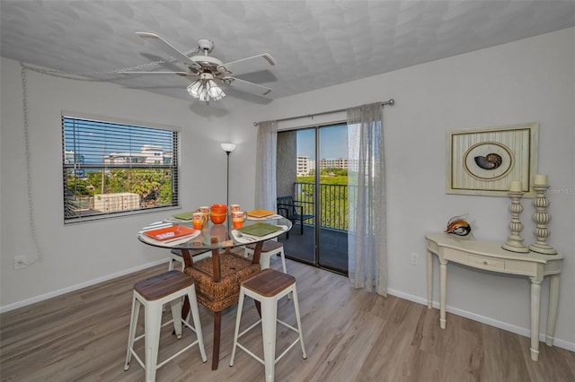 dining area with a ceiling fan, wood finished floors, and baseboards