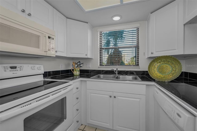 kitchen featuring tile countertops, white appliances, white cabinets, and a sink