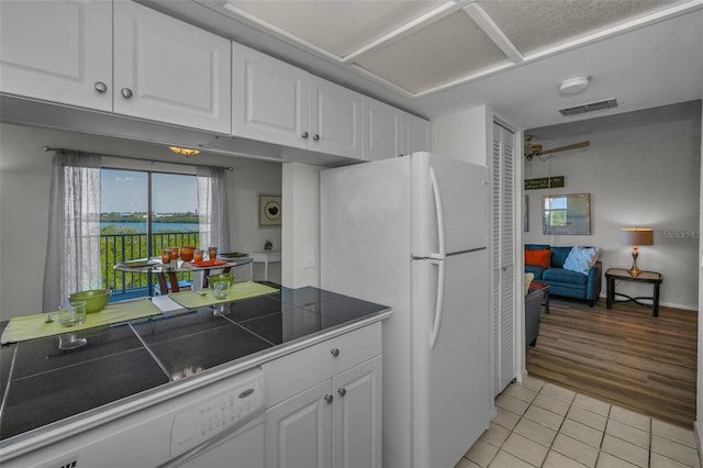 kitchen featuring visible vents, tile counters, light tile patterned flooring, white appliances, and white cabinetry