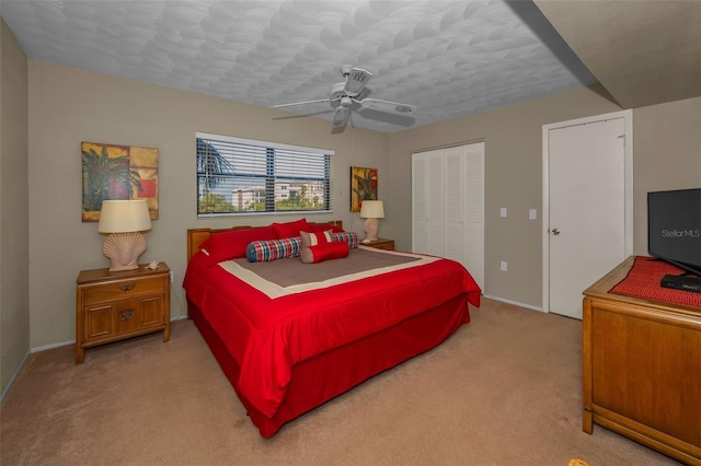 bedroom featuring a ceiling fan, carpet, a closet, and baseboards