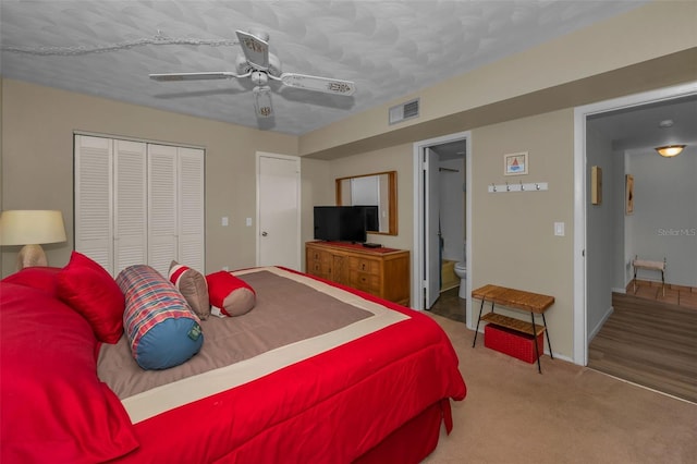 bedroom with visible vents, carpet floors, ceiling fan, a closet, and ensuite bathroom