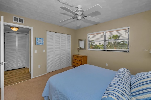 bedroom with visible vents, carpet, and ceiling fan