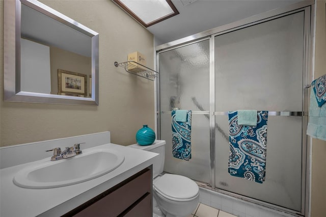 bathroom with tile patterned flooring, a shower stall, vanity, and toilet