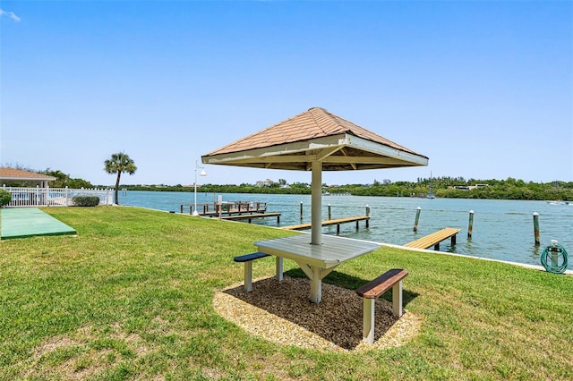 dock area featuring a lawn and a water view