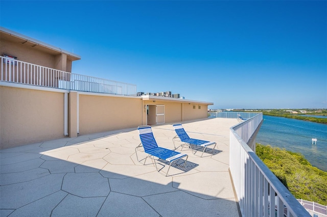 view of patio featuring a balcony and a water view