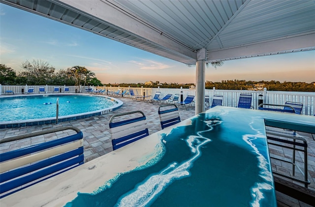 pool featuring outdoor dining space, a patio, and fence