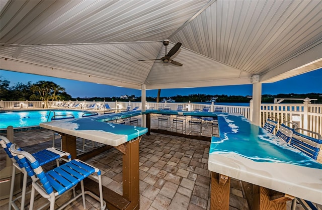 view of patio / terrace featuring a community pool, ceiling fan, and fence