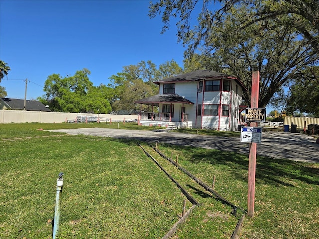 view of front of house with a front lawn and fence