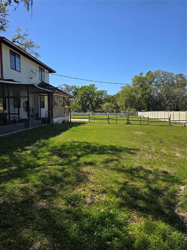 view of yard featuring a sunroom and fence