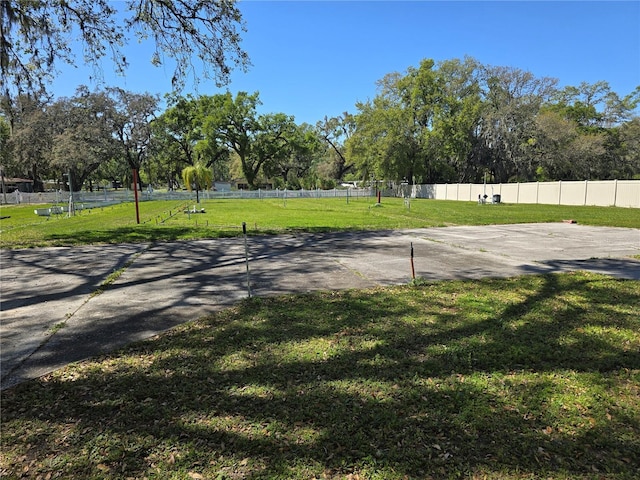 view of home's community with a yard and fence