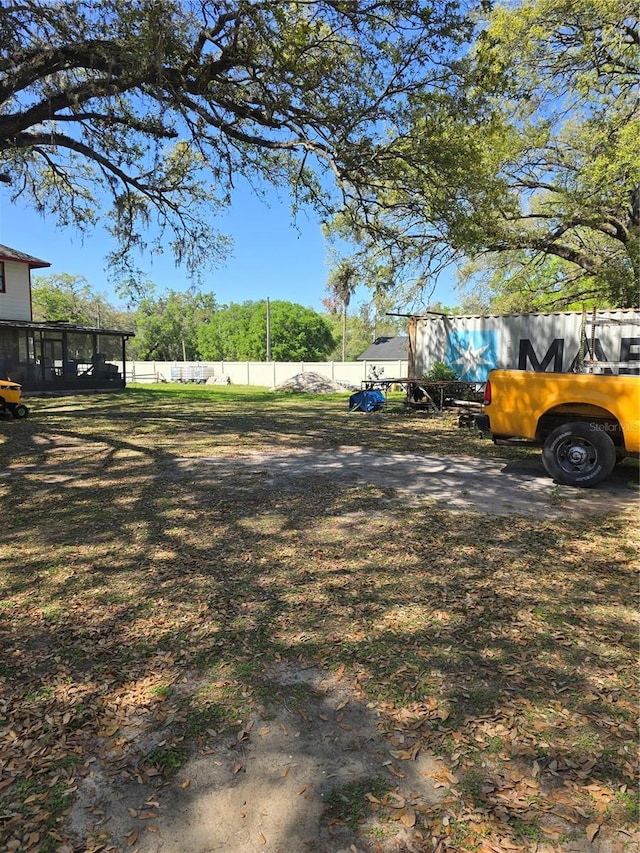 view of yard featuring a sunroom and fence