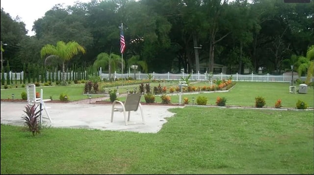 view of property's community with a lawn and fence