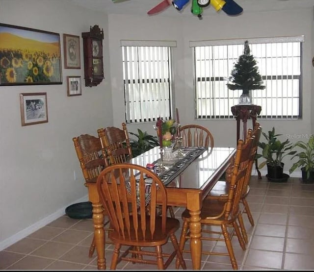 dining room with tile patterned floors, baseboards, and ceiling fan