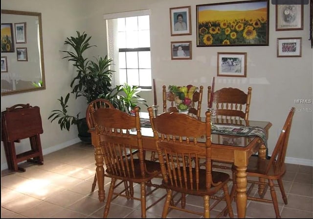 tiled dining room featuring baseboards