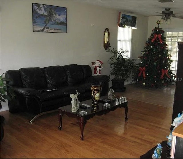 living area with visible vents, ceiling fan, and wood finished floors