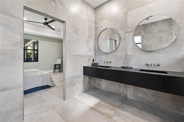 full bath with a sink, connected bathroom, tile walls, and a ceiling fan