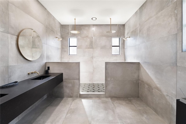 full bathroom with tile walls, vanity, and a walk in shower