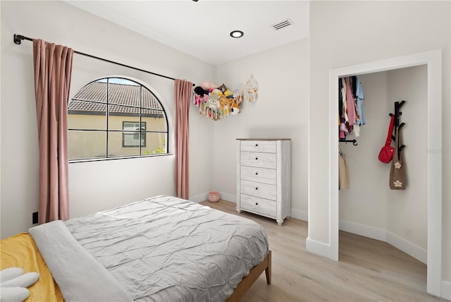 bedroom featuring light wood finished floors, visible vents, recessed lighting, and baseboards