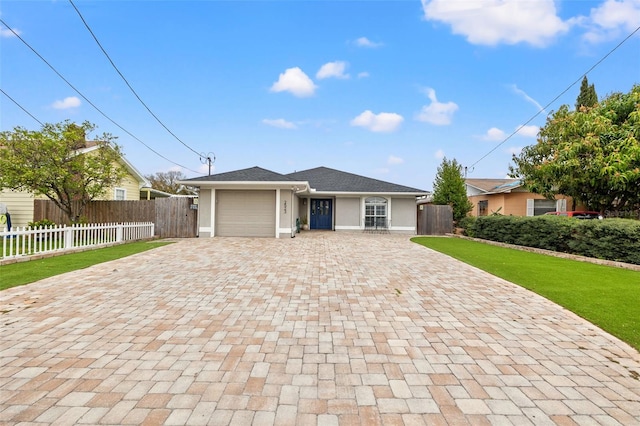 ranch-style house with fence, an attached garage, stucco siding, a front lawn, and decorative driveway