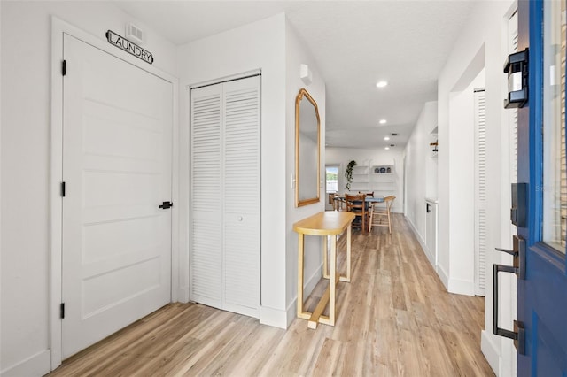 hall with recessed lighting, light wood-style flooring, and baseboards