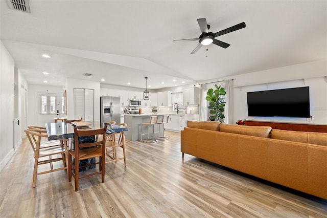 living area with recessed lighting, visible vents, lofted ceiling, and light wood-style floors