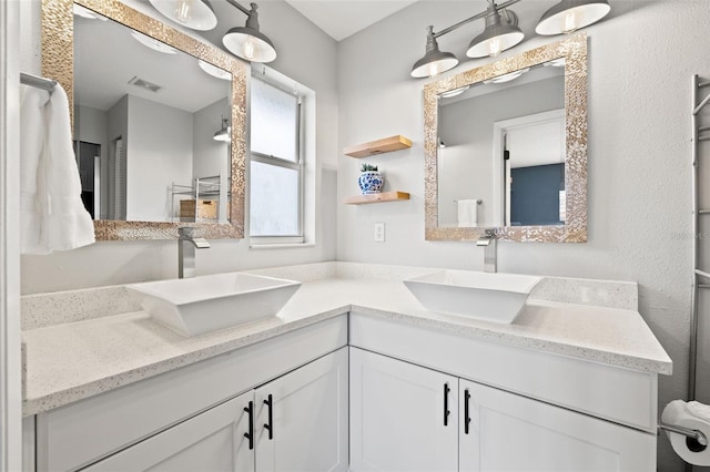 bathroom featuring double vanity, visible vents, and a sink