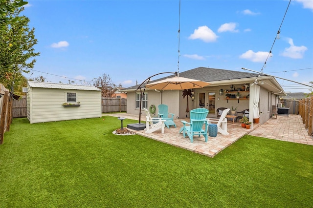 rear view of property featuring a lawn, french doors, a fenced backyard, and stucco siding