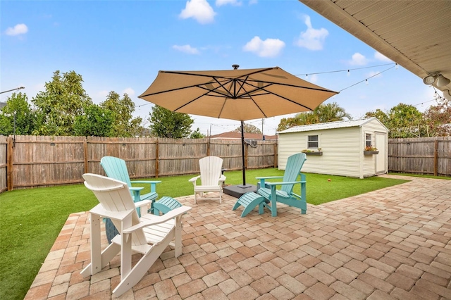 view of patio featuring an outbuilding, a fenced backyard, and a shed