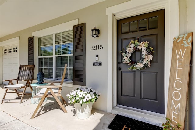 entrance to property featuring covered porch and stucco siding