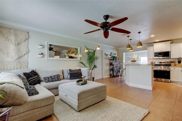 living room with light tile patterned floors, a ceiling fan, a textured ceiling, and crown molding