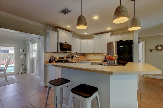 kitchen featuring light tile patterned floors, visible vents, appliances with stainless steel finishes, and crown molding