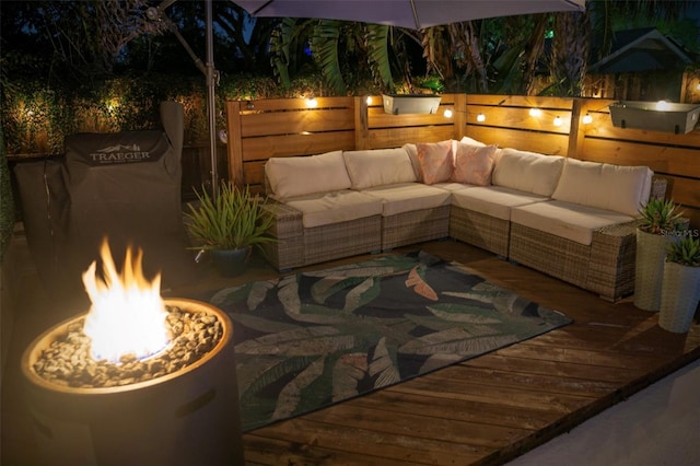 view of patio with an outdoor living space with a fire pit