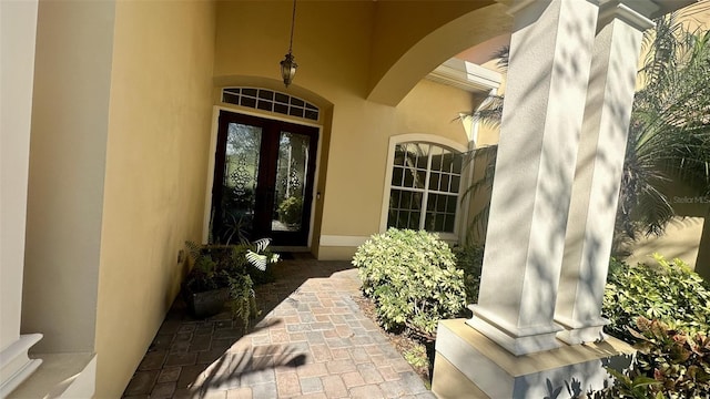 property entrance with stucco siding and french doors