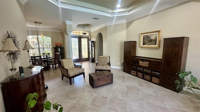 sitting room with baseboards, visible vents, arched walkways, ornamental molding, and a raised ceiling