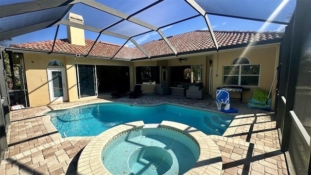 view of swimming pool featuring a patio, a ceiling fan, a pool with connected hot tub, and a lanai