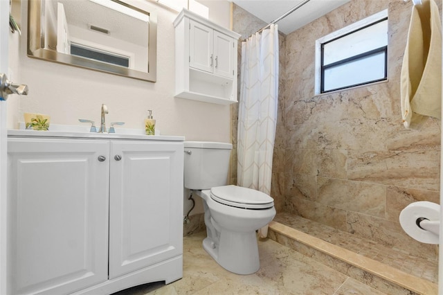 full bath with vanity, toilet, and tiled shower