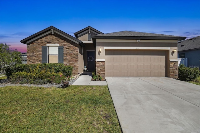 view of front of house with a front yard, an attached garage, stucco siding, concrete driveway, and stone siding