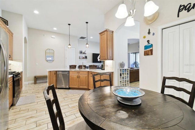 dining space featuring visible vents, light wood finished floors, baseboards, recessed lighting, and arched walkways