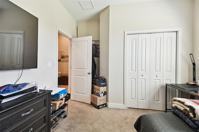 bedroom with light colored carpet, visible vents, and a closet