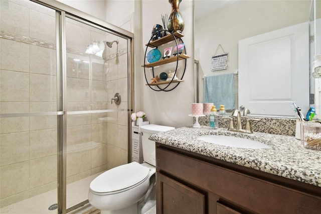 bathroom featuring vanity, toilet, and a stall shower