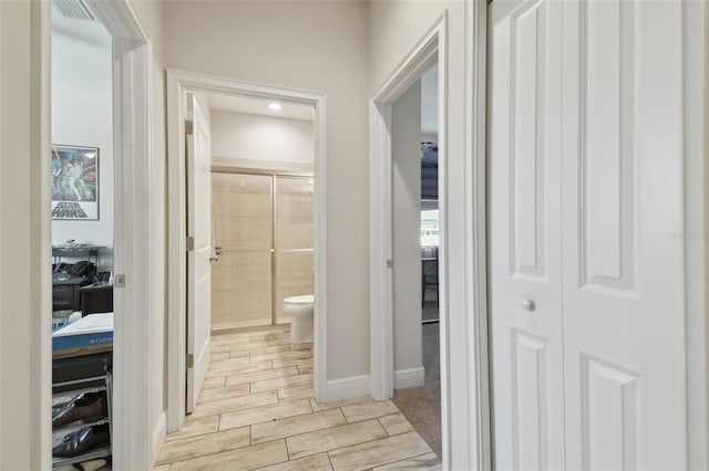 hall with baseboards and wood tiled floor