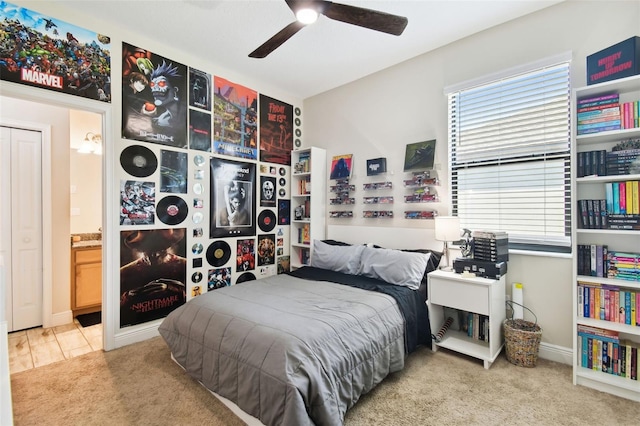 carpeted bedroom with a ceiling fan and ensuite bathroom