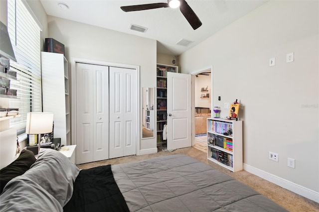 bedroom with baseboards, visible vents, ceiling fan, a closet, and light carpet