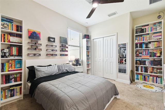 carpeted bedroom featuring a closet, visible vents, baseboards, and a ceiling fan