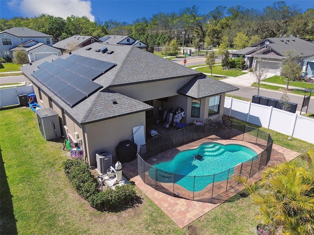 view of pool featuring a lawn, a patio, a fenced backyard, cooling unit, and a residential view